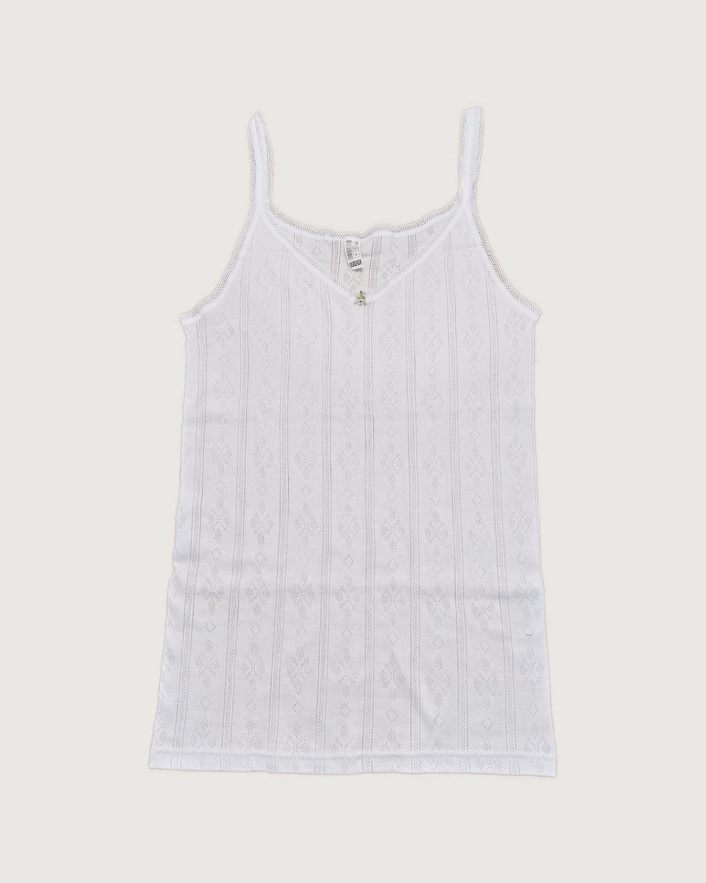 White tank top with thin straps on a light gray background